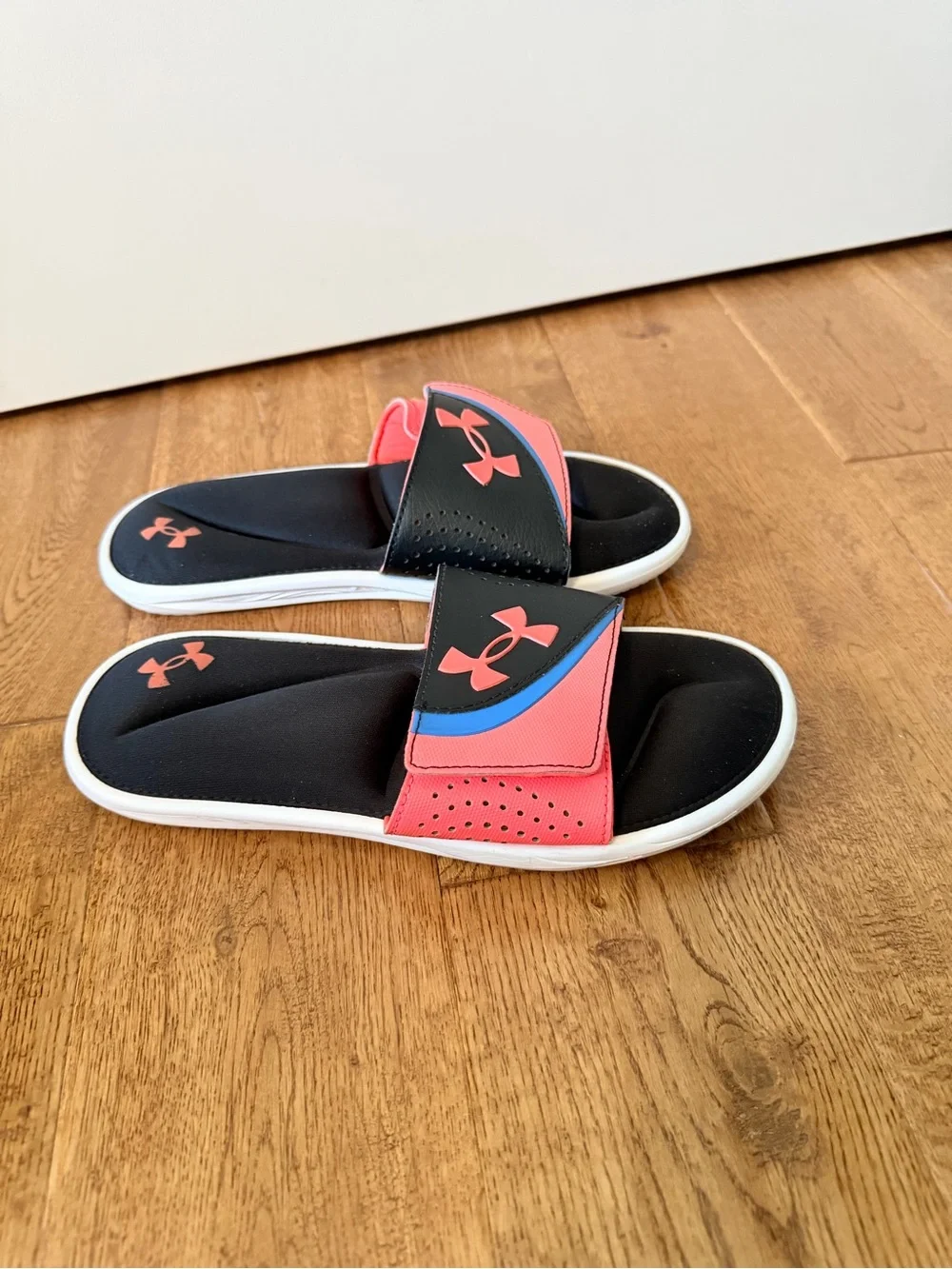 Under Armour Ignite VI coral and black slides with pink and blue accents sandals